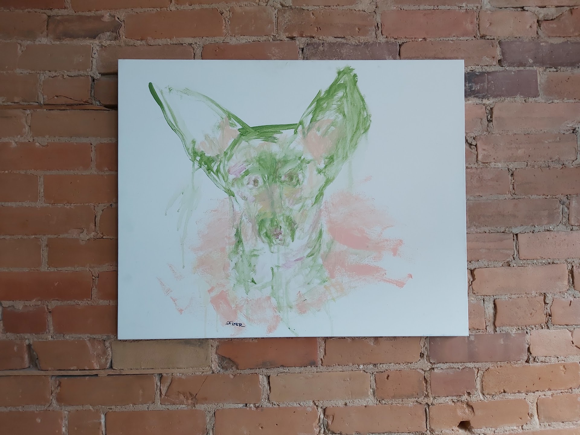 Dog portrait artwork on brick wall inside clinic