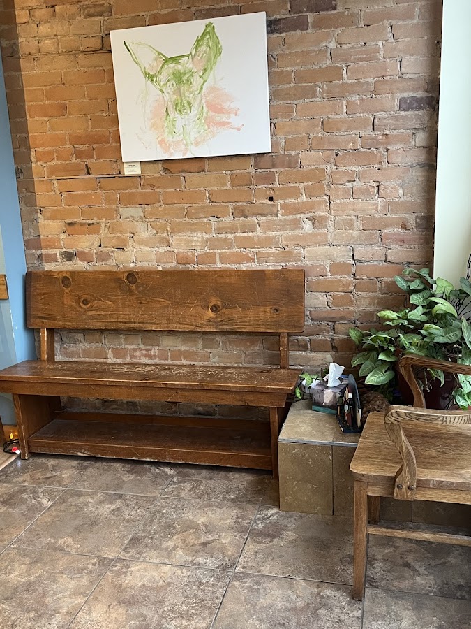 Warm waiting area with wooden bench and brick wall